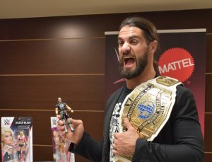 Seth Rollins posando con su figura