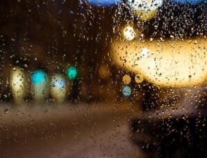 Detalle del interior de la ventanilla de un coche con exterior lluvioso