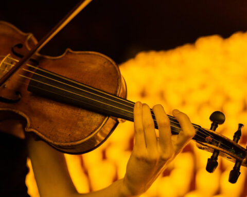 Violinista en un concierto de Candlelight, con sus famosas velas de fondo