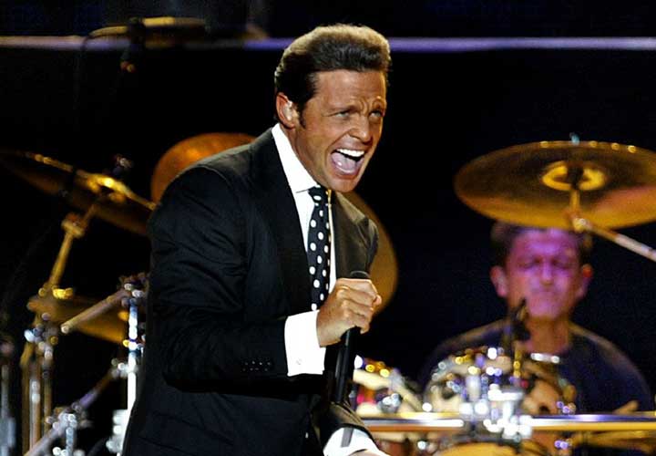 Luis Miguel cantando en vivo en un concierto.