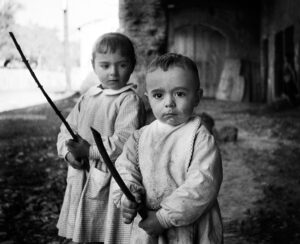 Fotografía de dos niños sosteniendo dos palos de madera.